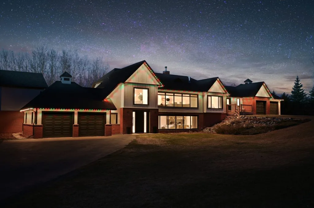 A contemporary house is illuminated under a starry night sky