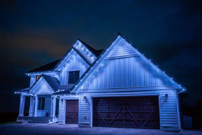 A house is elegantly adorned with blue lights against a dark sky