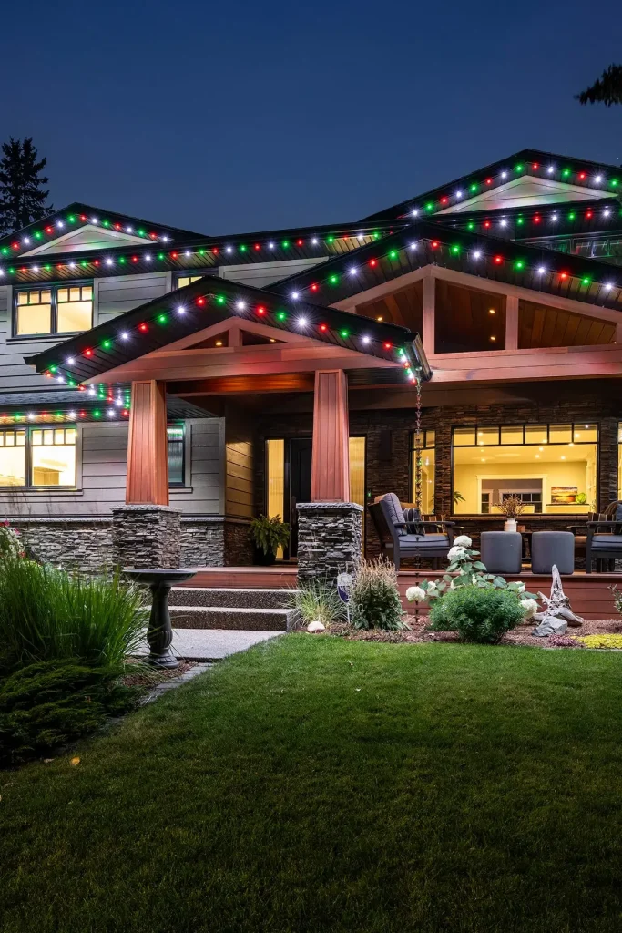 A beautifully decorated home adorned with colorful holiday lights twinkles in the evening