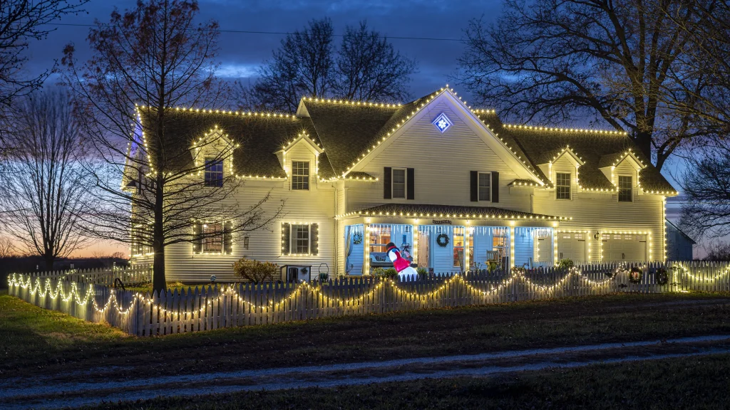 A beautifully lit house is adorned with festive decorations at twilight